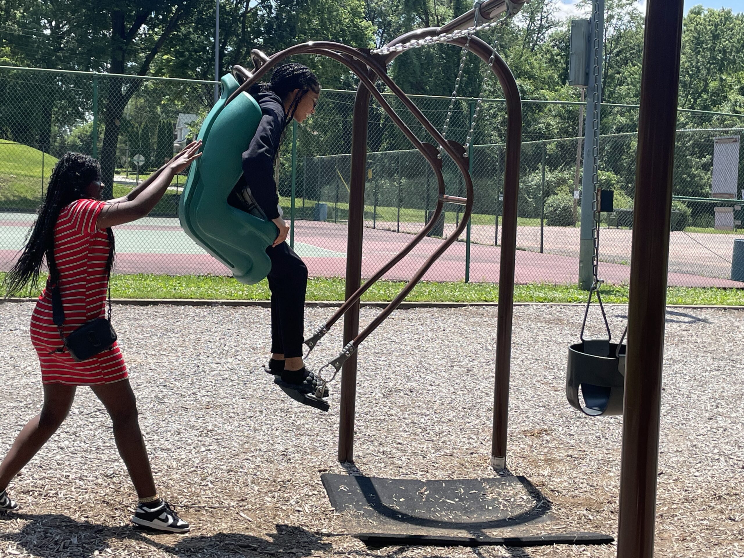 girl pushing friend on swing