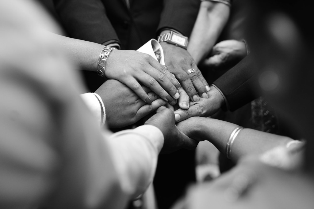 many hands holding one another in a circle